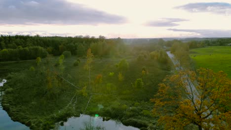 Luftaufnahmen-Am-Teich-Im-Herbst,-Bäume-Ohne-Blätter,-Kahle-Baumstämme,-Bunte-Landschaft-Ringsum,-Schöner-Sonnenuntergang,-Ermland-Und-Masuren,-Polen