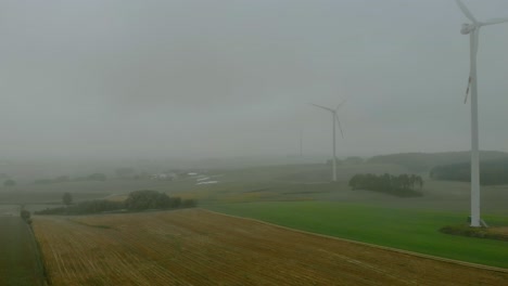 Luftaufnahmen-Aus-Der-Nähe-Von-Windpark,-Windmühle-Bei-Nebel,-Graue-Landschaft-Drumherum,-Erneuerbare-Energie-Auf-Freiem-Feld,-Unten-Naturlandschaft,-Grüne-Energie-Ist-Wichtig