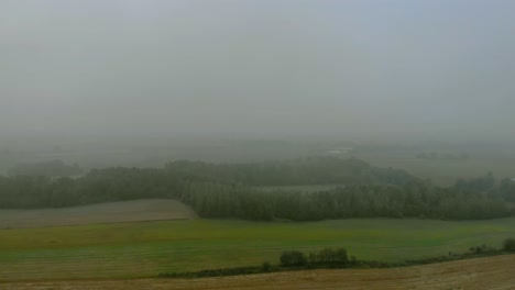 Aerial-footage-close-up-to-wind-farm,-windmill-during-fog,-grey-landscape-around,-renewable-energy-in-the-open-field,-below-natural-landscape,-green-energy-is-important