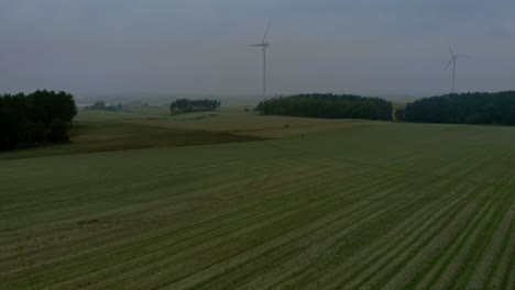 Aerial-footage-in-foggy-morning-at-the-wind-farm,-windmills-close-together-in-the-field