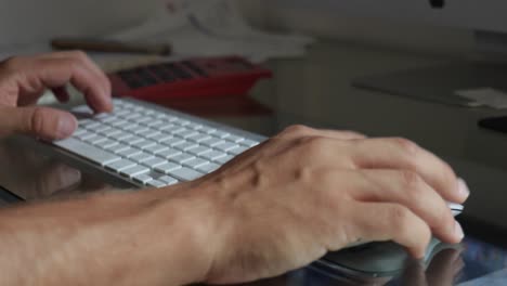 Männliche-Hände-Nahaufnahme,-Die-Auf-Einer-Bluetooth-Tastatur-Tippen-Und-Die-Maus-über-Den-Glastisch-Ziehen