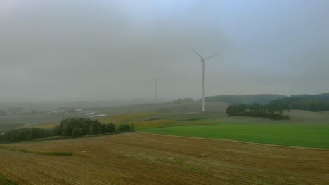 Luftaufnahmen-Aus-Der-Nähe-Von-Windpark,-Windmühle-Bei-Nebel,-Graue-Landschaft-Drumherum,-Erneuerbare-Energie-Auf-Freiem-Feld,-Unten-Naturlandschaft,-Grüne-Energie-Ist-Wichtig