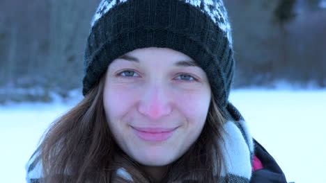 Französisches-Mädchen-Mit-Hut-Im-Winter,-Der-In-Zeitlupe-In-Die-Kamera-Mit-Schnee-Lächelt