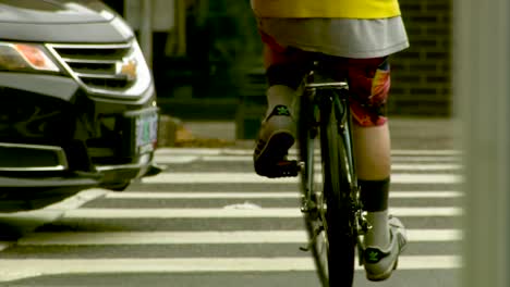 Bicyclist-waiting-at-a-crosswalk-and-then-crossing-the-street