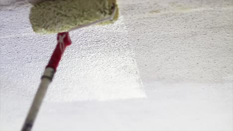 Roller-painting-a-wall-with-white-color-in-slow-motion