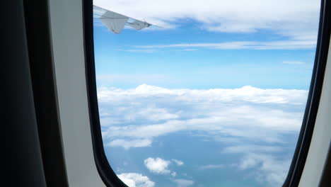 Blick-Auf-Den-Blauen-Und-Bewölkten-Himmel-Aus-Dem-Flugzeugfenster