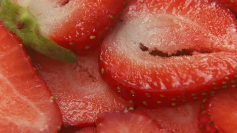4k-super-close-up-macro-sliced-strawberries,-tilting-down-slowly-over-cut-strawberry-slices,-healthy-fruit
