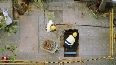 Top-View-Of-Constructor-Worker-Digging-Shoveling-and-Breaking-a-Concrete-on-a-street-in-Barcelona