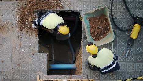 Top-View-Close-Up-Of-Constructor-Workers-Digging-Shoveling-and-Breaking-a-Concrete-on-a-street-in-Barcelona