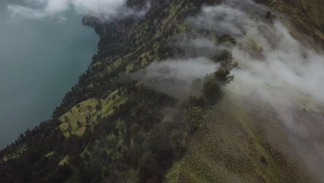AERIAL-4K-Clouds-Pouring-over-Mount-Rinjani-Crater-Rim-3,-Indonesia