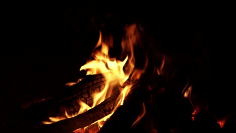 Orange-flames-on-black-background,-close-up-of-fireplace