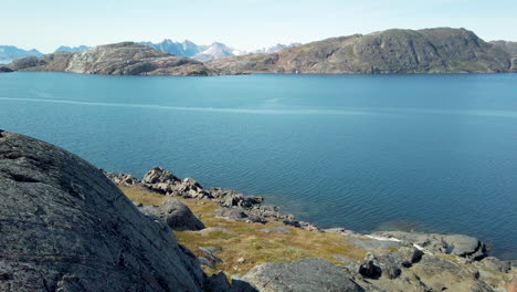 Scenic-view-of-rocky-shoreline-along-coast-of-Greenland-from-top-of-rocks-lining-the-beach