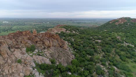 Aerial-view,-Backward-shot-of-Reveling-rock-mountain-vegetation-in-Karnataka,-India