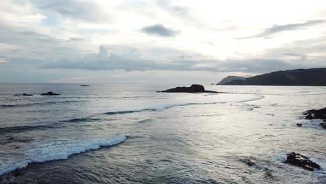 AERIAL-4K-Small-Waves-Crashing-over-Ocean-Rocks,-Indonesia