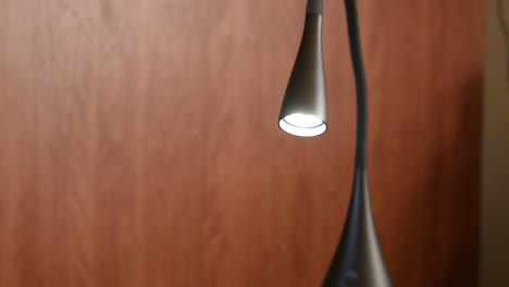 Illuminated-lit-modern-minimalist-trendy-desk-lamp-close-up-focus-on-light-bulb
