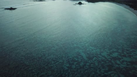 Luftaufnahme-Mit-4k-Hochschwenk-über-Klarem-Blauem-Wasser-Bei-Sonnenuntergang-In-Indonesien