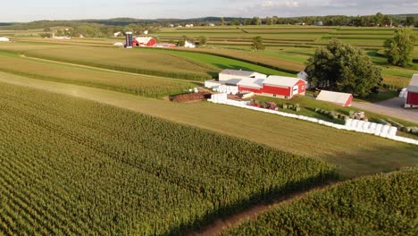 Aerial-fly-in-to-reveal-round-bale-plastic-wrapping-on-family-dairy-farm-in-Pennsylvania