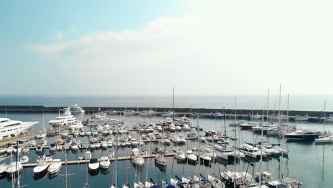 Aerial,-marina-full-of-boats-on-calm-smooth-water-morning,-pedestal-up