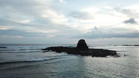 AERIAL-4K-Panning-Shot-of-Jagged-Ocean-Rocks-at-Sunset