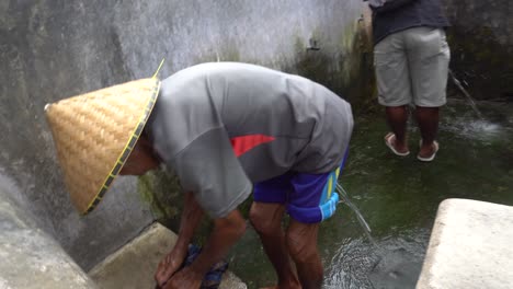 Hombre-Lavando-Ropa-Tradicionalmente-En-Un-Pueblo-Indonesio