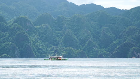Long-Shot-Of-A-Passenger-Boat-In-Coron-Palawan,-Beside-Mountains