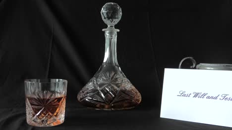 An-envelope-holding-a-Will-is-put-on-a-desk-beside-a-glass-of-whisky-and-whisky-decanter