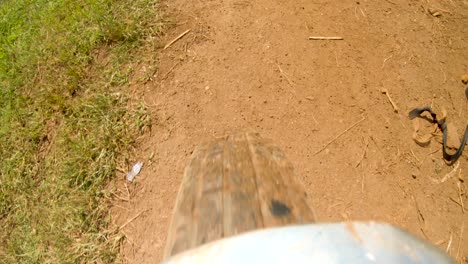 A-action-shot-of-a-motor-bike-starting-to-turn-while-riding-on-a-dirt-road-in-rural-Africa