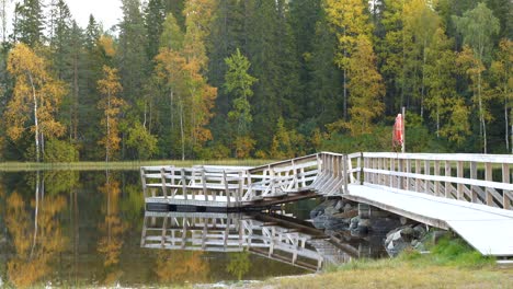 Static-footage-of-a-wooden-Jetty-reaching-out-into-the-autumn-lake