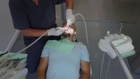 A-man-is-laying-at-the-dentist-while-the-doctor-works-in-his-mouth