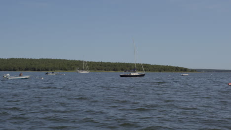 Slow-pan-of-boats-floating-in-a-lake-in-Cape-Cod-on-a-beautiful-summer-day