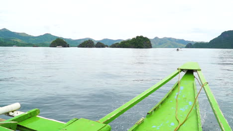 Riding-In-Front-Of-A-Small,-Green-Passenger-Boat-In-Coron-Palawan