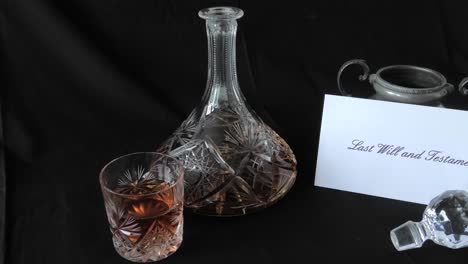 An-envelope-holding-a-Will-is-put-on-a-desk-beside-a-glass-of-whisky-and-whisky-decanter