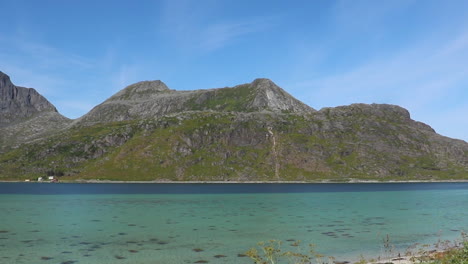 Pequeña-Playa-En-Un-Fiordo-En-Noruega-Con-Grandes-Montañas-Detrás