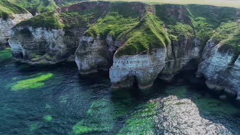 Beautiful-chalk-coastal-cliffs-at-low-tide,-with-visible-cracks-showing-in-the-cliff-faces