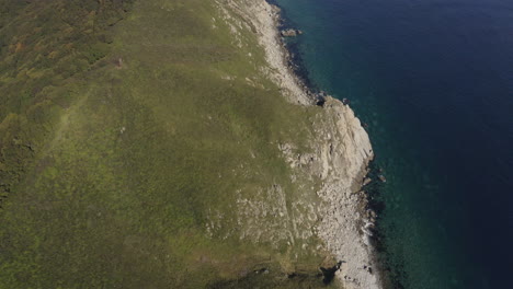 Vogelperspektive-Auf-Eine-Atemberaubende-Steile-Felsküste-Und-Einen-Tiefblauen-Ozean