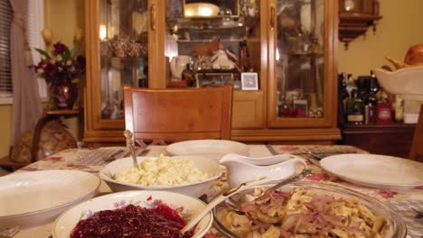 Placing-a-Thanksgiving-turkey-on-a-table-full-of-food,-ready-for-a-feast-in-slow-motion-4K