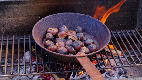 Chestnuts-cooked,-roasted-in-pan-over-fire,-traditional-rustic-dessert