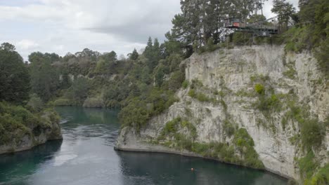 A-static-wide-shot-of-someone-bungy-jumping-over-the-Waikato-river-in-Taupo,-NZ