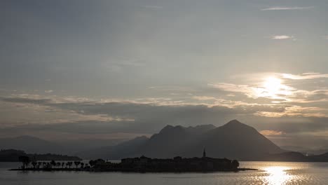 Ein-Sonnenaufgang-Im-Zeitraffer-Des-Vorbeifahrenden-Schiffsverkehrs-Auf-Der-Insel-Pescatori-Am-Italienischen-Lago-Maggiore