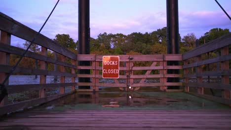 Wide-shot-of-Docks-Closed-sign-at-a-closed-boating-docks-gate-during-sunset