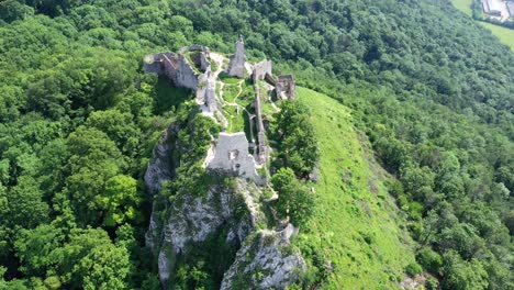 Flight-above-the-abandoned-and-ruined-medieval-Plavecky-Castle-on-a-rock,-Slovakia