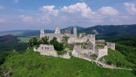 Aerial-footage-of-a-ruined-medieval-castle-on-a-hill,-Slovakia