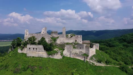 Aerial-footage-of-a-ruined-medieval-castle-on-a-hill,-Slovakia