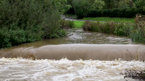 The-river-Gwash-flowing-through-the-village-of-Braunston-in-Rutland-heavily-swollen-after-heavy-rains