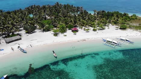 Zoom-Aéreo-De-4k-Fuera-De-Una-Playa-Aislada-Que-Revela-Agua-A-Ambos-Lados-De-Una-Pequeña-Isla-En-Balabac,-Palawan,-Filipinas