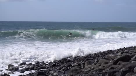 Zeitlupenaufnahmen-Eines-Surfers,-Der-An-Einem-Felsigen-Strand-Eine-Große-Welle-Bekommt