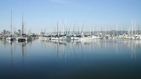 A-clean-pan-right-over-glassy-smooth-waters-as-the-boats-glisten-in-the-sunny-bay