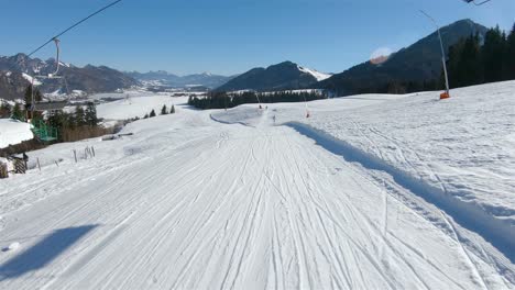 Skier-goes-down-the-slope-at-the-ski-slopes-and-in-front-of-him-opened-the-mountain-panorama-of-the-valley