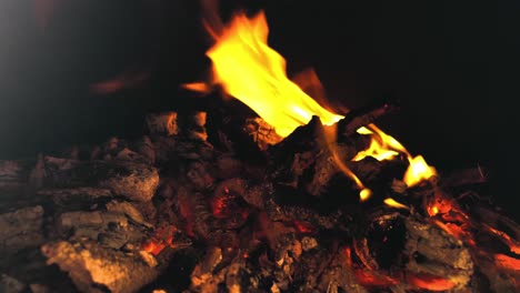 Flames-dancing-in-a-dark-firepit-with-a-blazing-pile-of-hot-coals