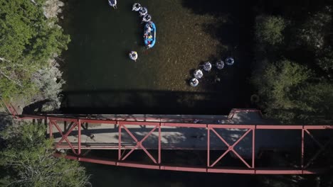 Luftbild-Menschen-In-Flößen,-Die-Unter-Der-Brücke-Auf-Dem-Fluss-Boise-Schwimmen